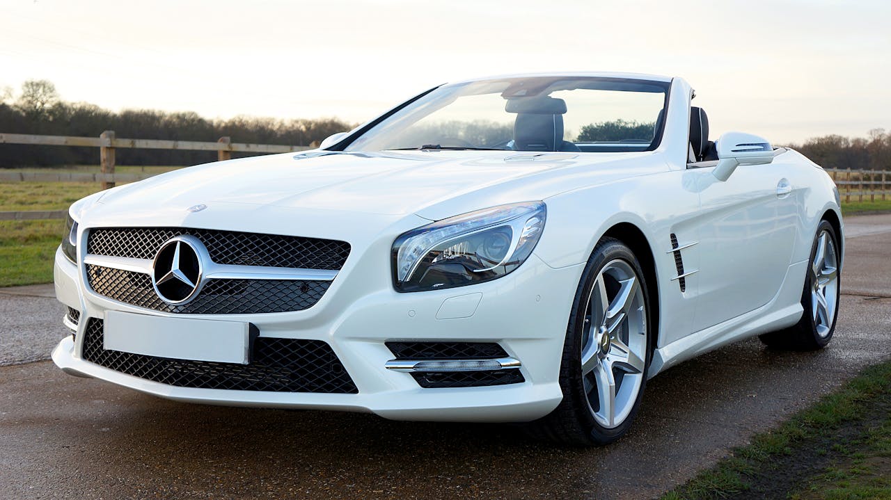 Elegant white Mercedes-Benz convertible on a scenic countryside road in the United Kingdom.